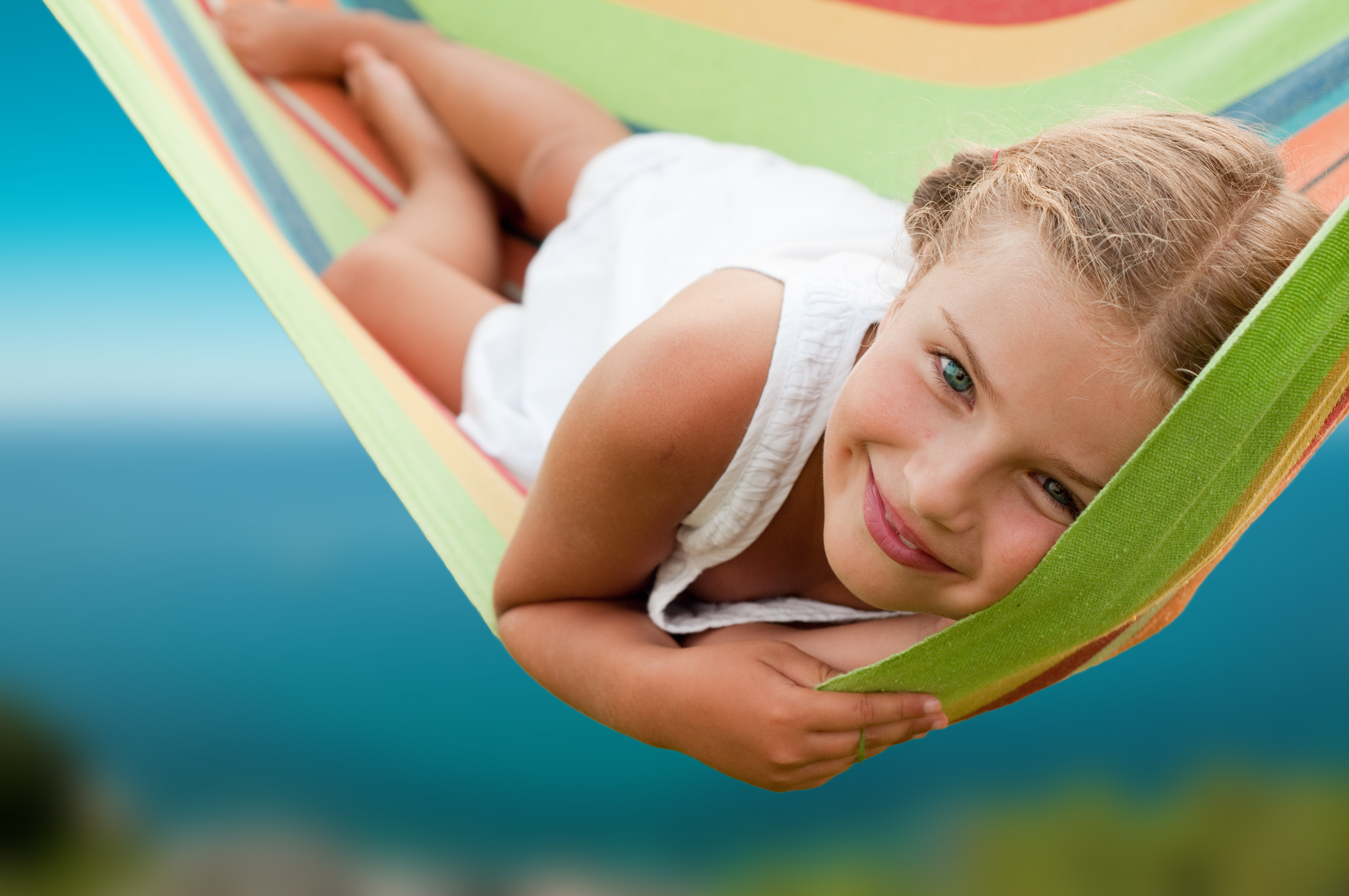 Summer vacation - Lovely girl resting in colorful hammock Summer vacation - Lovely girl resting in colorful hammock