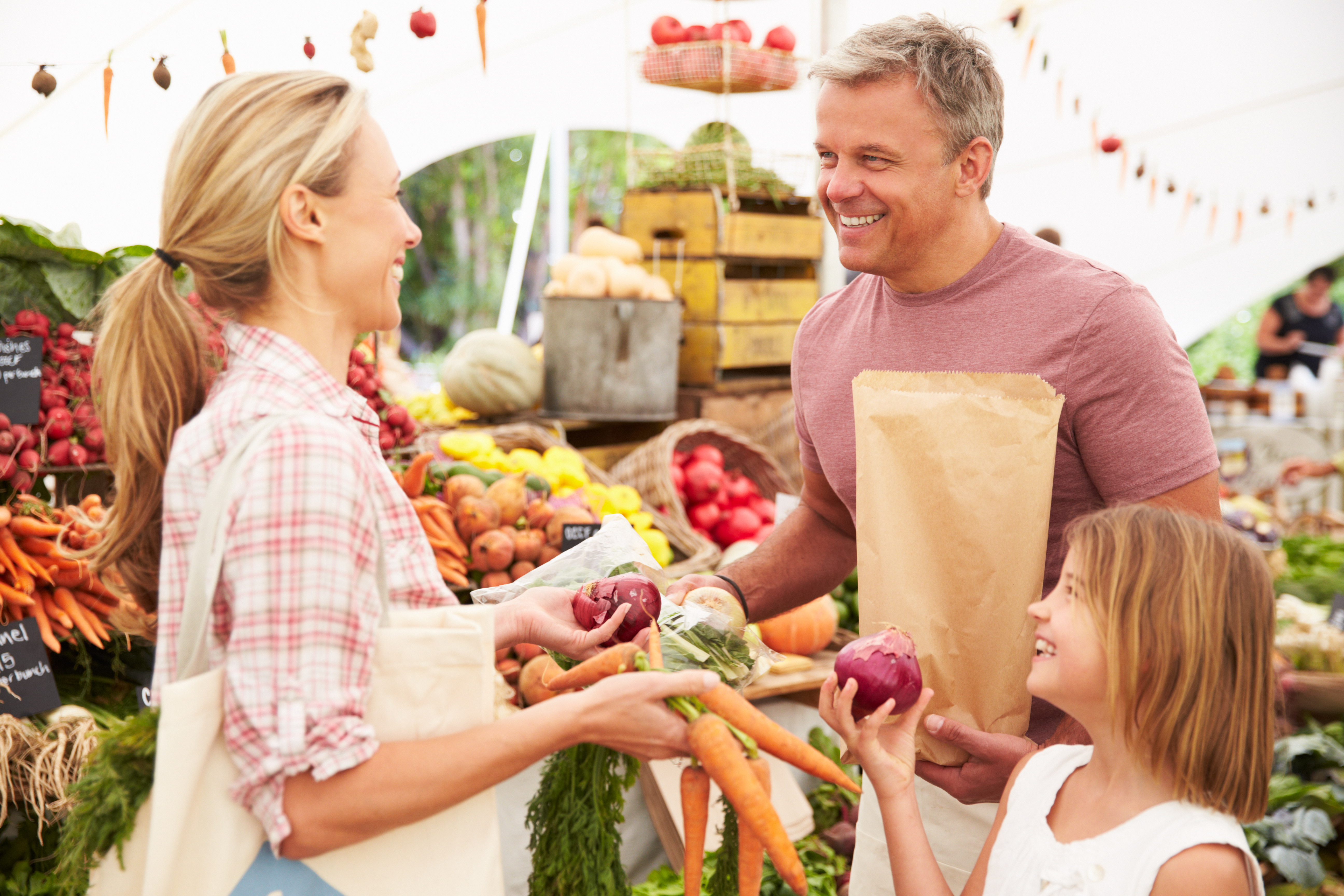 Family Buying Fresh Vegetables At Farmers Market Stall Family Buying Fresh Vegetables At Farmers Market Stall